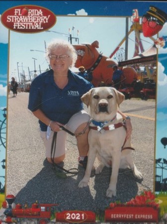 Debbie and Penny, my guide dog, a yellow lab at the Florida Stawberry Festival.